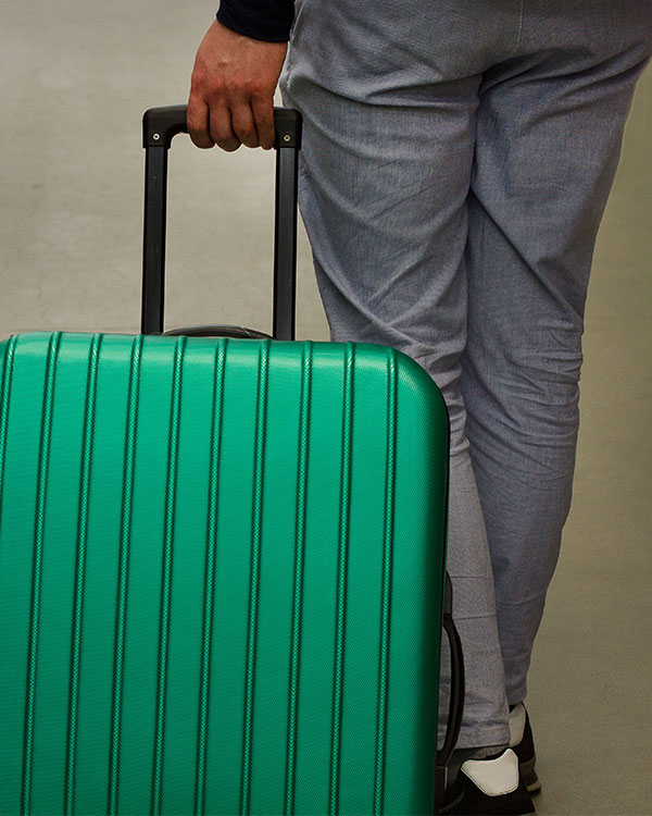 A man pulls a wheeled suitcase