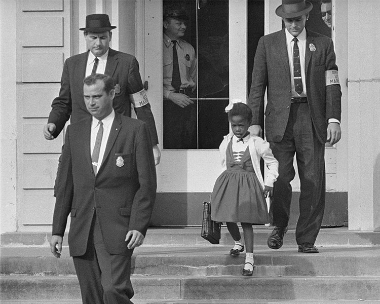 An African American student is escorted at school by federal agents.