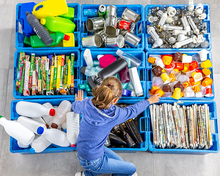 Student sorting recyclables into bins