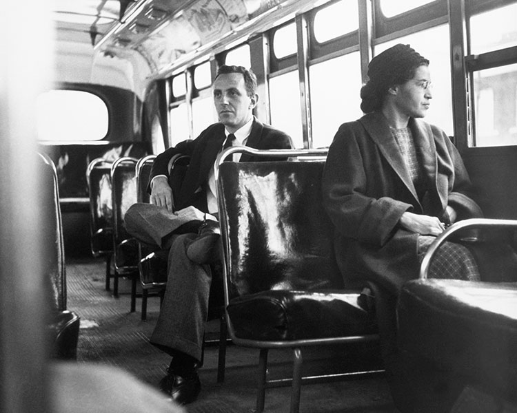 Black & white photo of Rosa Parks riding a segregated bus