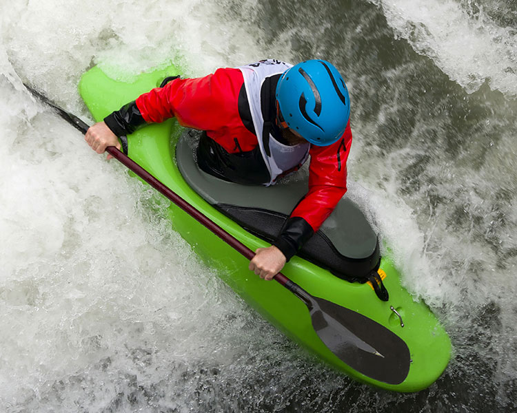 man kayaking through rough river water