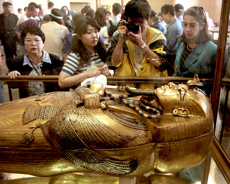 A group of people looking at the mummy&apos;s tomb in a museum