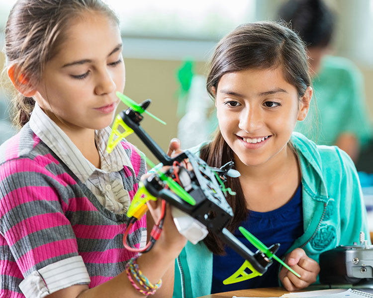 Two girls looking at a drone