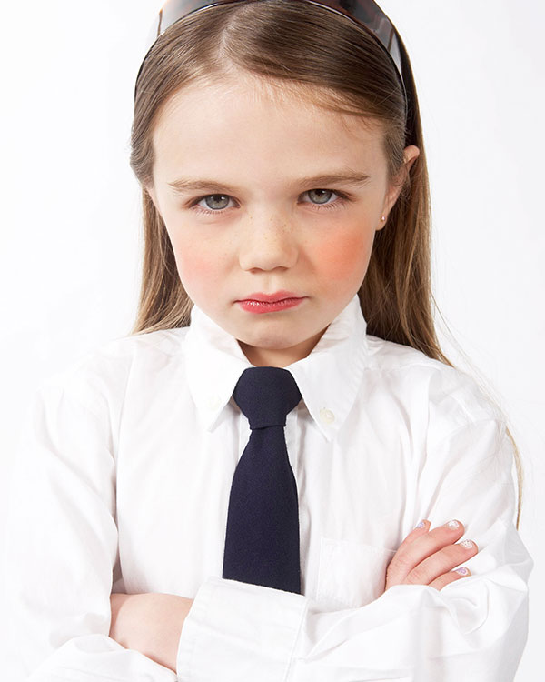 Kid frowning with crossed arms in a suit and tie