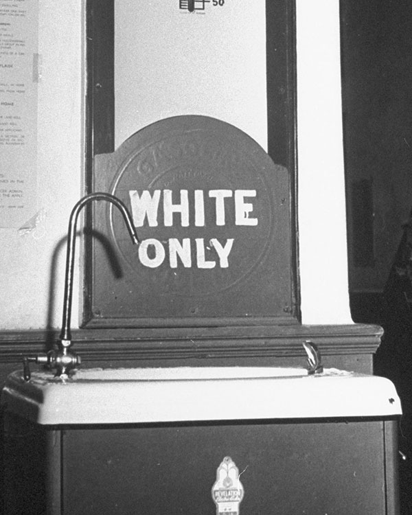 Black & white photo of a sink labeled, "White Only"