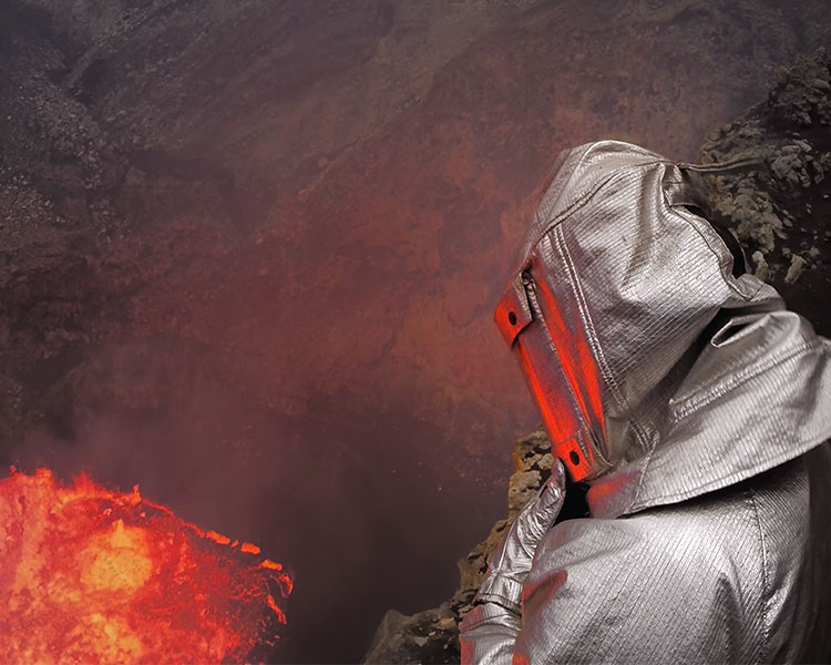 Photo of a person wearing a protection suit while standing next to lava