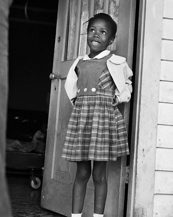 Black & white photo of a student smiling while wearing a uniform