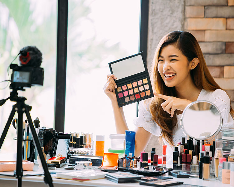 Photo of a person filming themselves doing a make-up tutorial