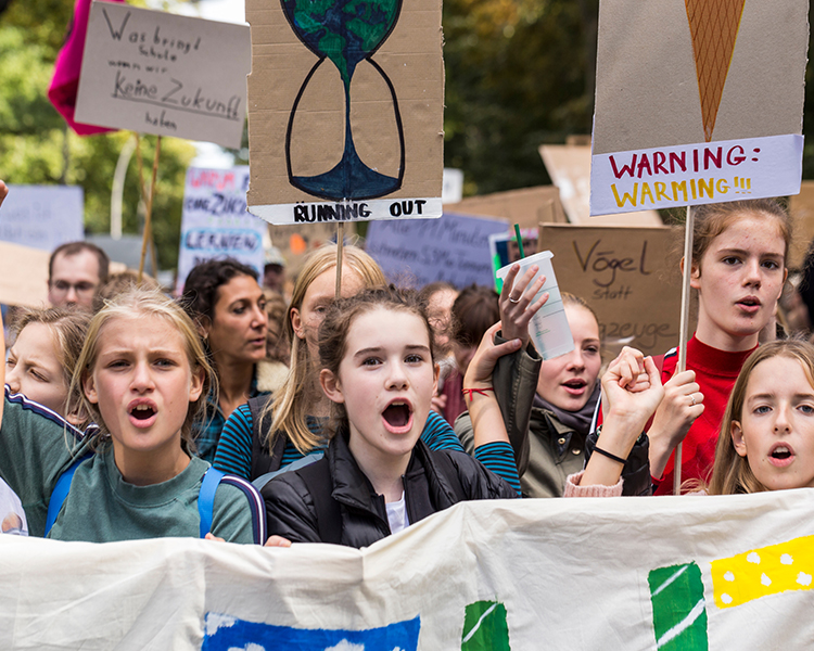 Students with signs protesting Climate Change