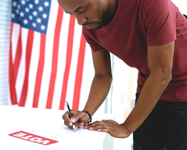 A person writing out their vote on a ballot