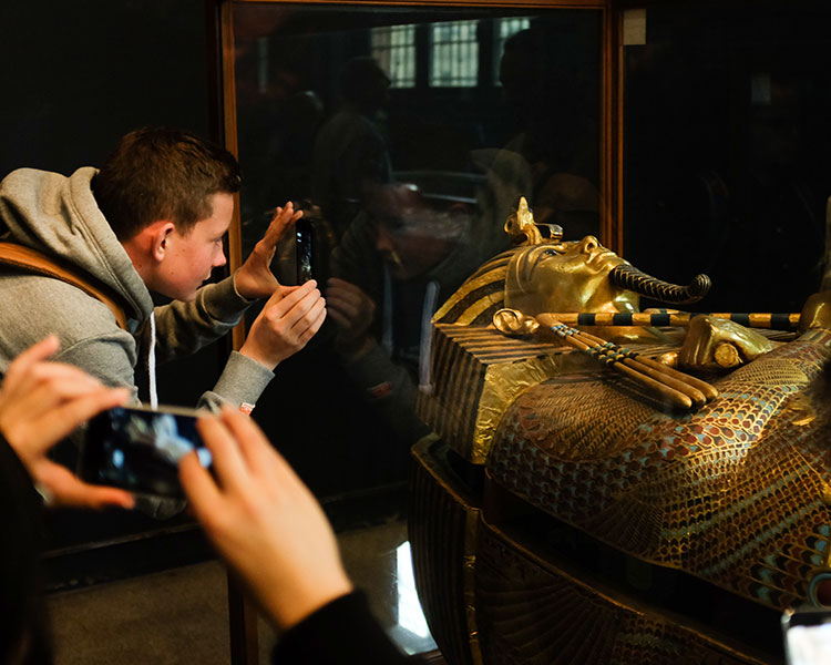 People taking pictures with their phone of a pharaoh&apos;s tomb