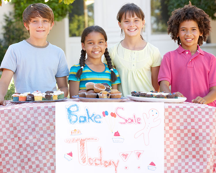 Photo of four kids holding a bake sale