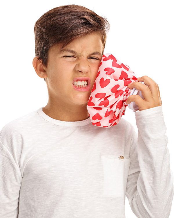 Image of a kid with a toothache and grimacing their face in pain