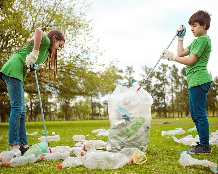 Photo of two kids picking up litter