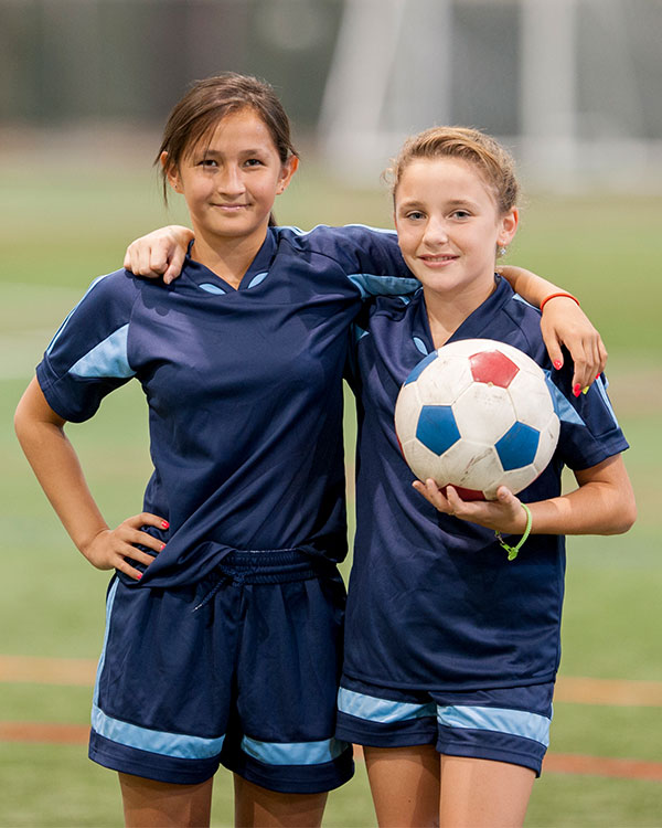 Two soccer teammates posing with the ball