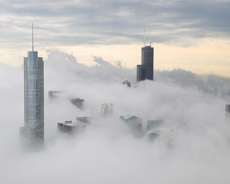 Image of a bird&apos;s eye view of a city layered in fog